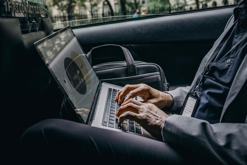 Professional executive working on laptop in luxury car, reach Volantis anytime